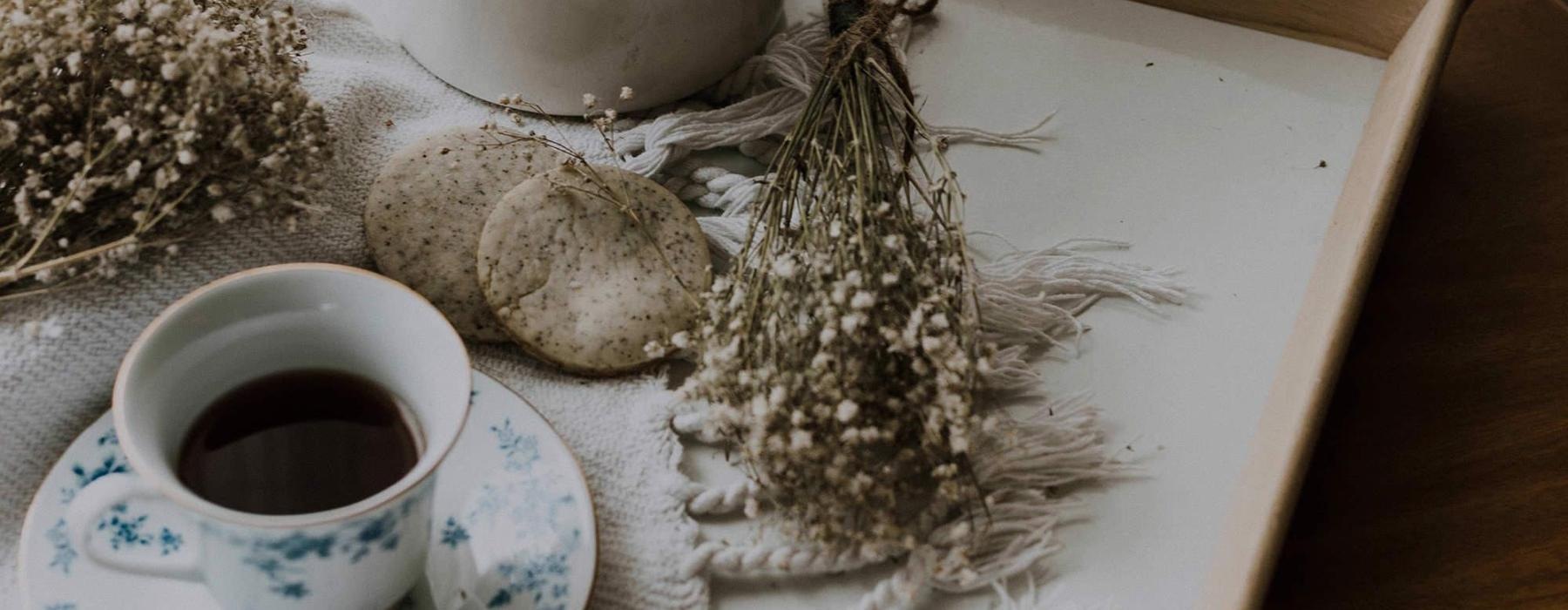 tea and cookies on a serving tray with baby's breath